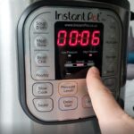 person setting the time on an air fryer