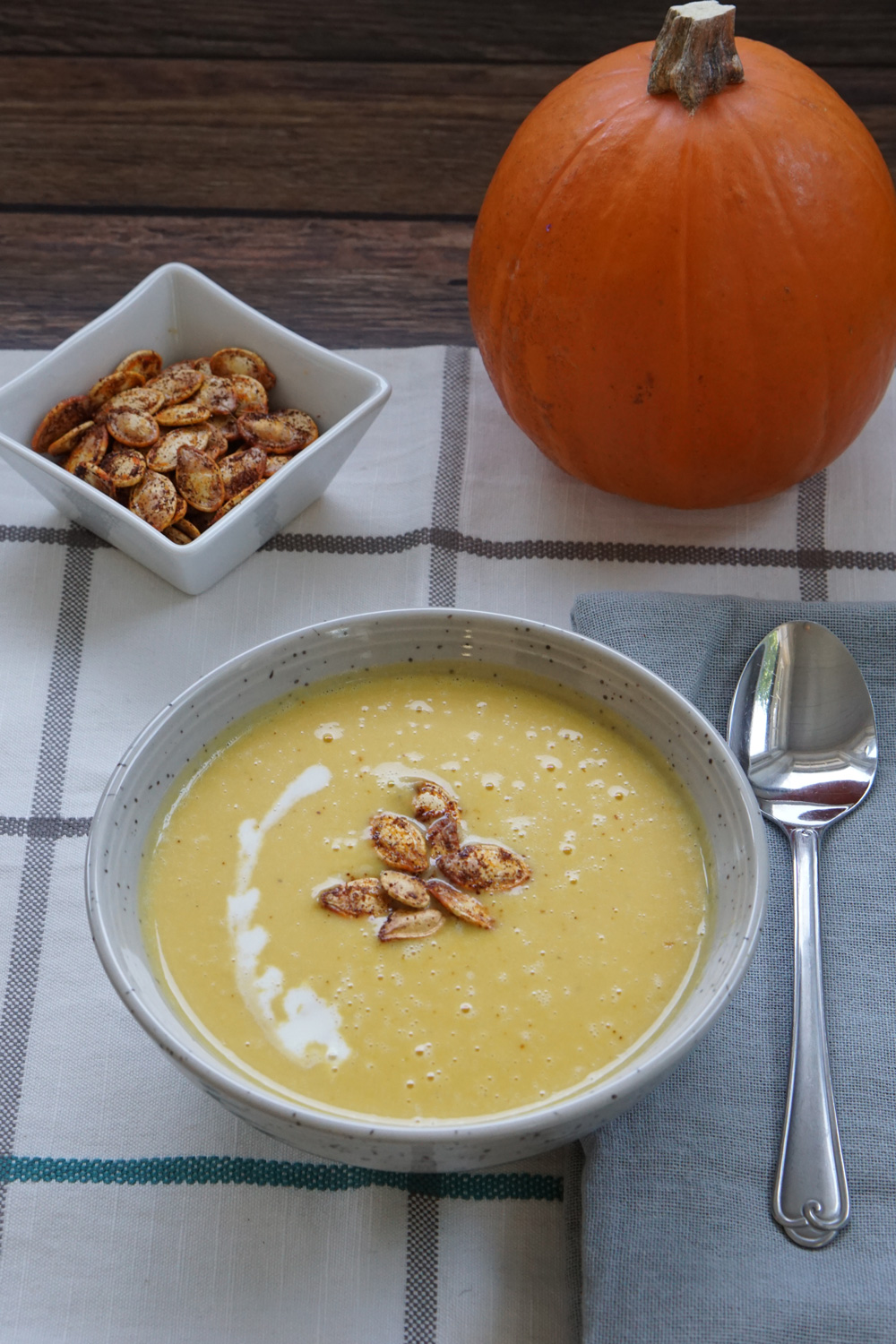 A bowl of pumpkin soup with pumpkin seeds on top