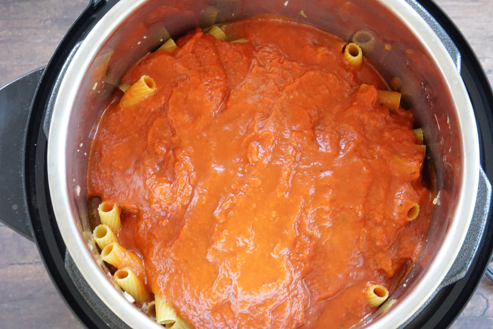 Uncooked pasta with sauce ready to pressure cook.